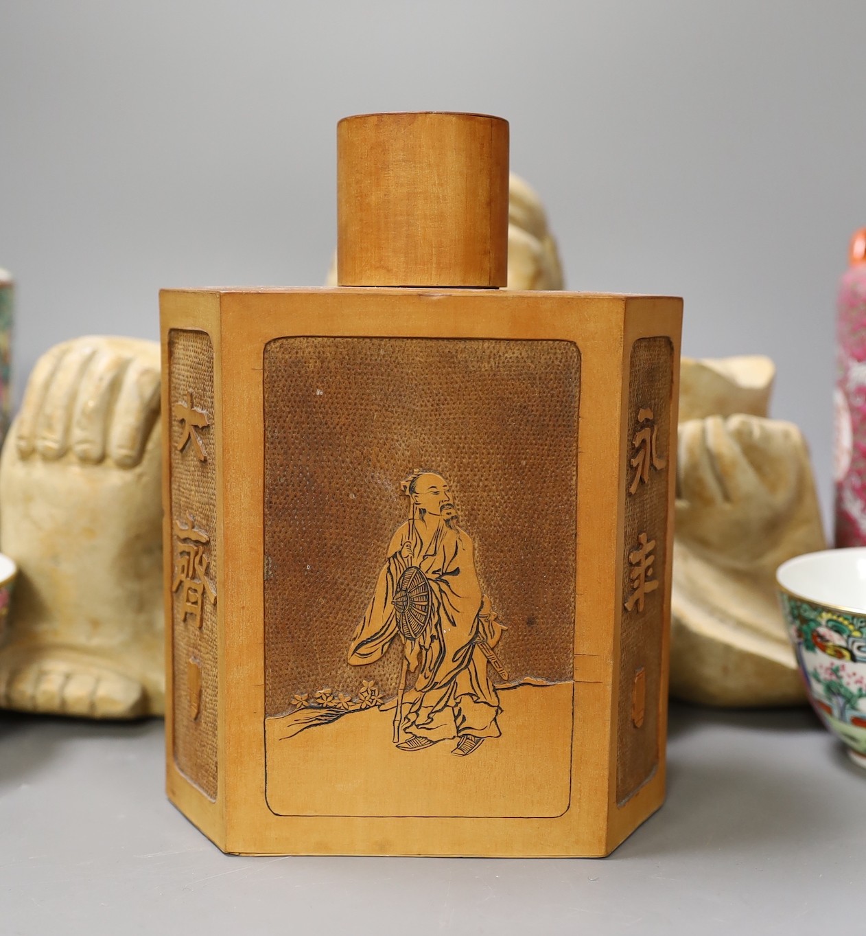 A Chinese wooden figure of Budai, two teapots in baskets and a tea caddy